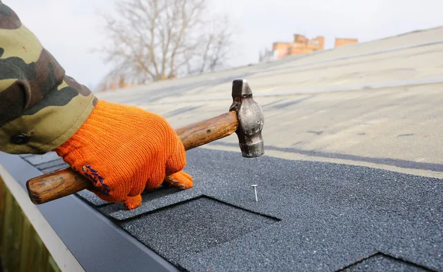Professional roof leak repair - expert roofer installing shingles to stop leaks